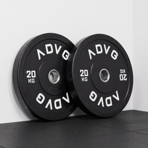 ADVG vulcanised rubber bumper Olympic weight plates, a pair of 20kg leaning on a white studio wall on a black rubber gym floor
