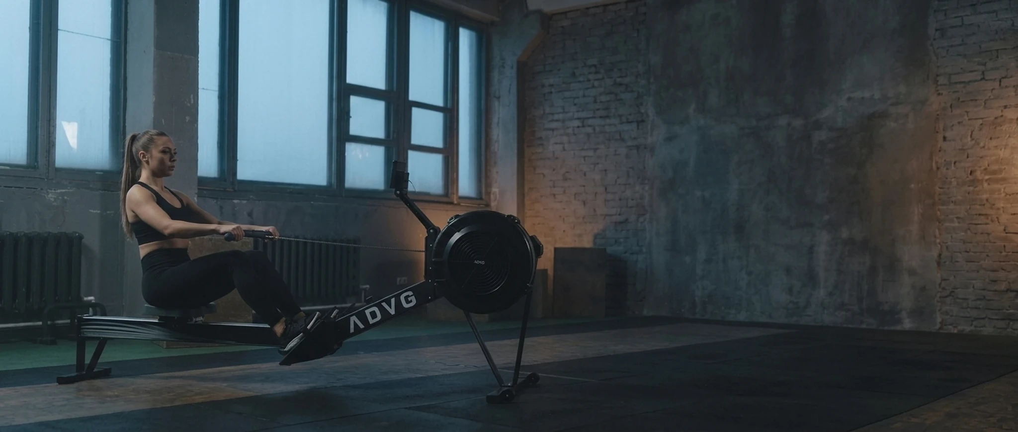 Woman rowing on an ADVG air rower in a gym