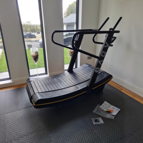 ADVG Commercial Curved Treadmill CurveMax 1.0 in a home gym by a tall window