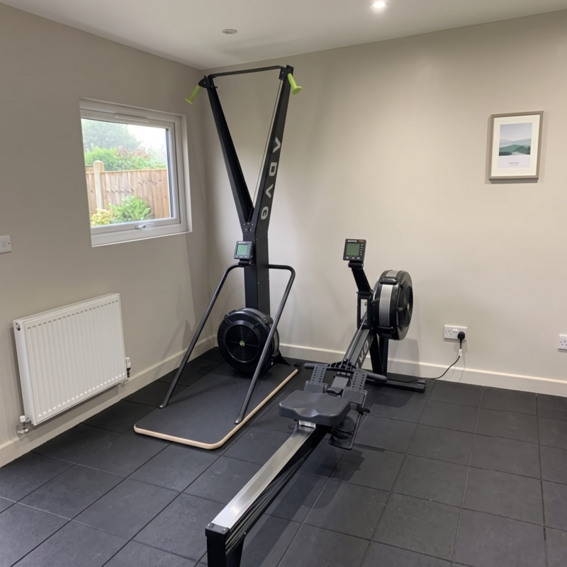 ADVG SkiErg and air rowing machine in a home gym with rubber floor tiles